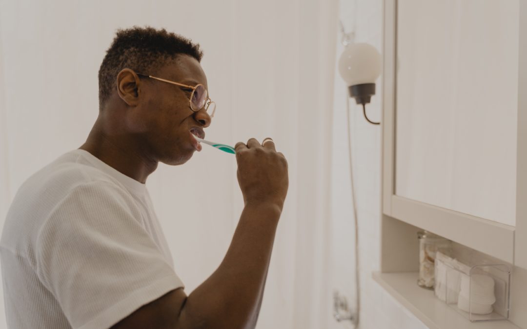 Man brushing teeth looking in the mirror
