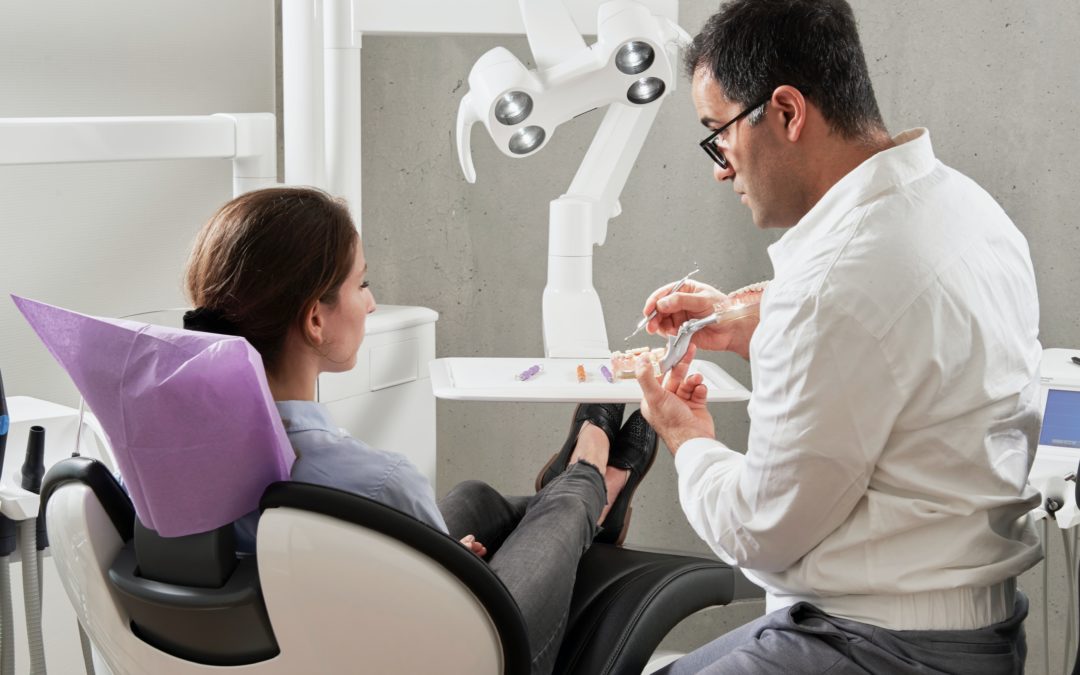 Dentist explaining to female patient her teeth health.