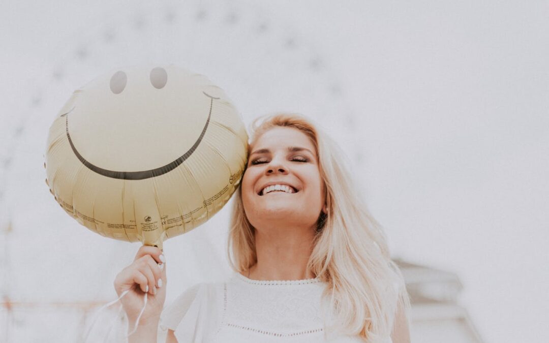 woman holding a smiley face balloon